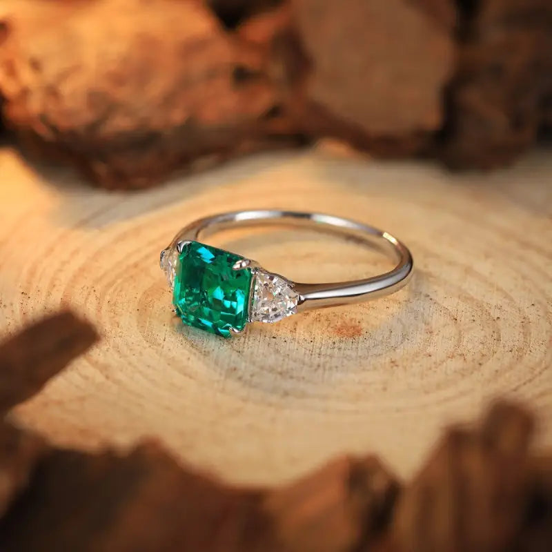 Emerald and diamond ring with a silver band.