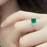 Load image into Gallery viewer, Emerald-cut green gemstone ring with small diamond accents.
