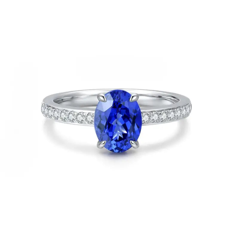 Sapphire and diamond engagement ring with an oval-cut center stone.