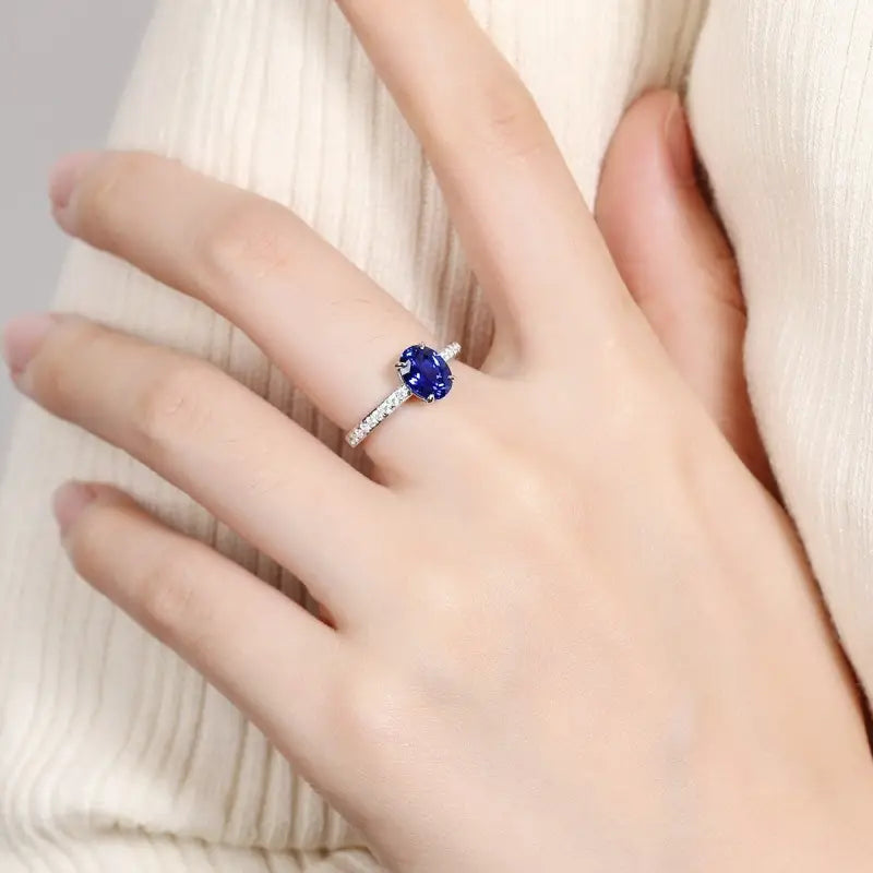 Sapphire and diamond ring on a person’s finger.