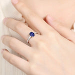 Load image into Gallery viewer, Sapphire and diamond engagement ring on a finger.
