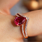 Load image into Gallery viewer, Rose gold ring featuring a pear-shaped ruby surrounded by diamond accents.
