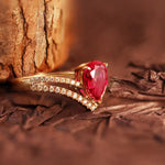 Load image into Gallery viewer, Gold ring with a pear-shaped red gemstone and diamond accents.
