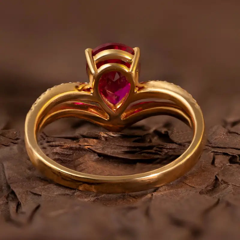 Gold ring with a pear-shaped ruby gemstone.