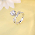 Load image into Gallery viewer, Elegant silver ring with a prominent diamond and curved, diamond-accented band.
