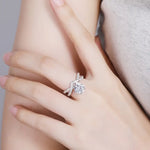 Load image into Gallery viewer, Sparkling diamond engagement ring with a floral-inspired design worn on a finger.
