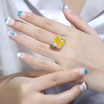 Load image into Gallery viewer, Yellow diamond ring surrounded by smaller clear diamonds.
