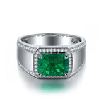 Load image into Gallery viewer, Silver ring featuring a rectangular emerald gemstone surrounded by small diamonds.
