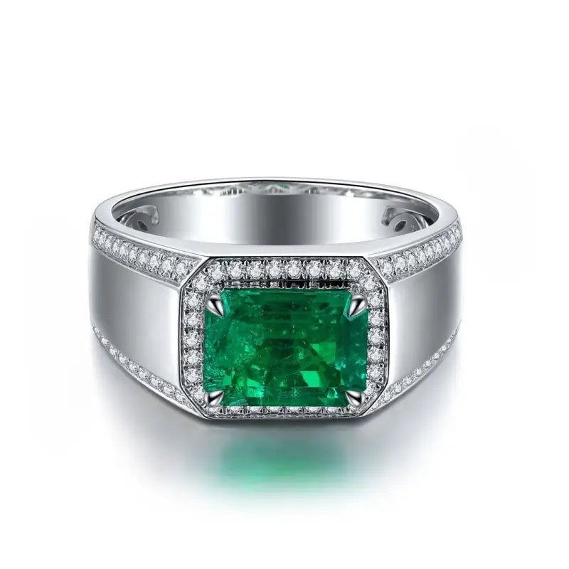 Silver ring featuring a rectangular emerald gemstone surrounded by small diamonds.