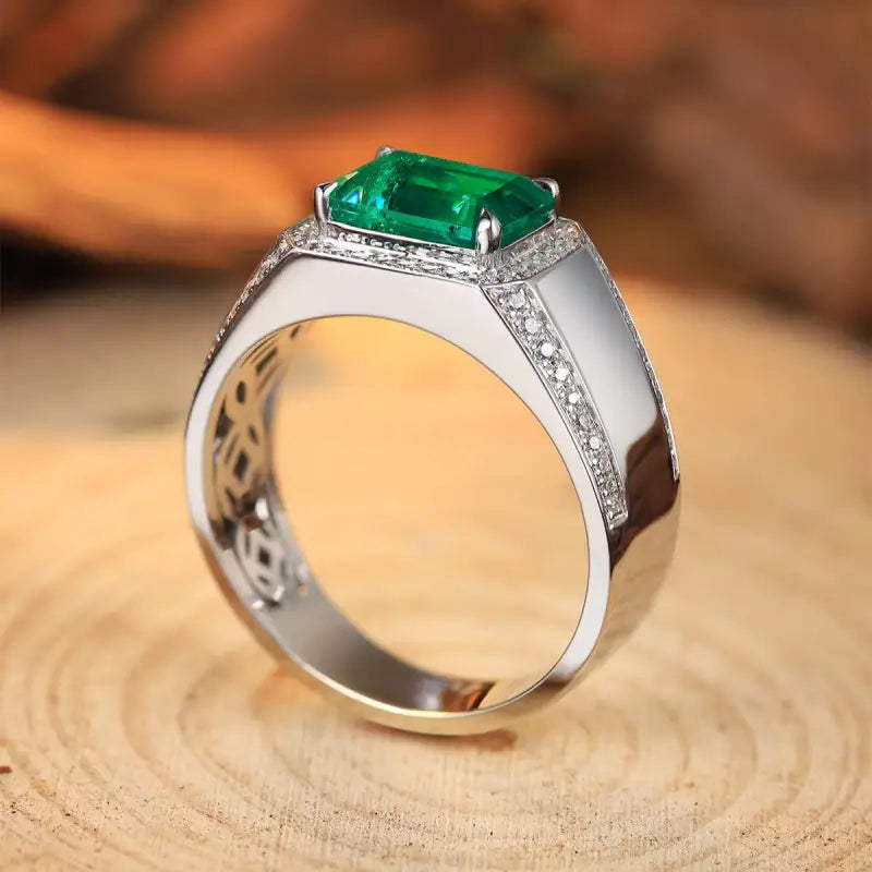 Silver ring featuring a prominent emerald-cut green gemstone surrounded by small diamonds.