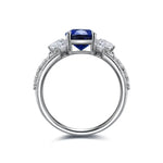 Load image into Gallery viewer, Elegant silver ring featuring a central blue gemstone flanked by smaller diamonds.
