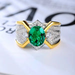 Load image into Gallery viewer, Ornate ring featuring a central oval emerald surrounded by diamonds in a gold and silver setting.
