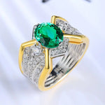 Load image into Gallery viewer, Ornate ring featuring a vibrant green gemstone surrounded by diamonds in a gold and silver setting.
