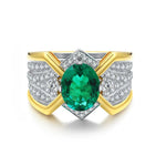 Load image into Gallery viewer, Ornate gold and silver ring featuring a prominent oval-cut emerald gemstone surrounded by diamonds.
