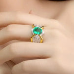 Load image into Gallery viewer, Ornate ring featuring a vibrant green gemstone surrounded by diamonds.
