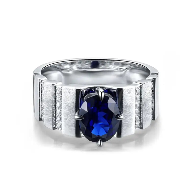 Silver ring with a prominent deep blue gemstone centerpiece and textured band design.