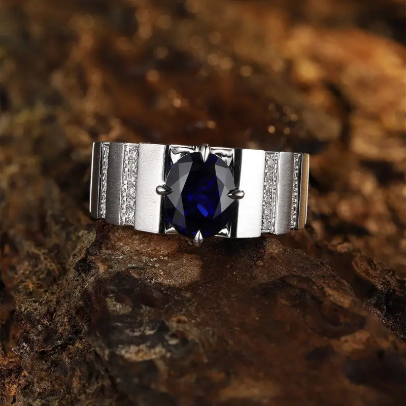 Silver ring with a deep blue gemstone and diamond accents.