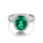 Load image into Gallery viewer, Oval emerald ring surrounded by diamonds in a white gold or platinum setting.
