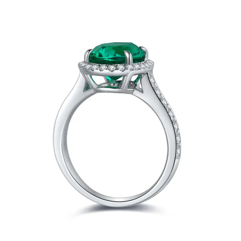 Elegant silver ring featuring a vibrant emerald-green gemstone surrounded by small diamonds.