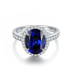 Load image into Gallery viewer, Oval-cut sapphire ring with diamond halo and pave band.
