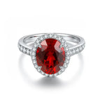 Load image into Gallery viewer, Oval-cut ruby ring with diamond halo and pave band.
