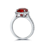 Load image into Gallery viewer, Silver ring with a prominent oval-cut red gemstone surrounded by small diamonds.
