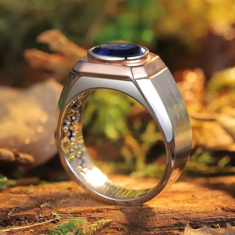 Silver ring with a round blue gemstone set in a bezel.