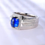 Load image into Gallery viewer, Silver ring with a prominent blue gemstone and small diamonds.
