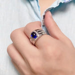 Load image into Gallery viewer, Ornate silver ring with a deep blue gemstone centerpiece.
