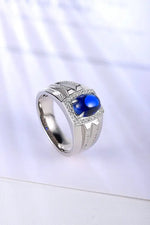 Load image into Gallery viewer, Silver ring with a prominent blue gemstone and small diamond accents.
