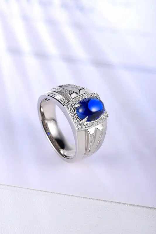 Silver ring with a prominent blue gemstone and small diamond accents.