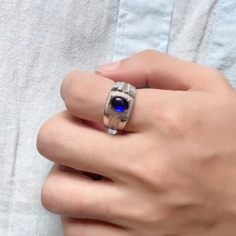 Silver ring with a prominent blue gemstone in the center.