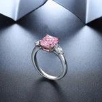 Load image into Gallery viewer, Engagement ring featuring a pink square-cut center stone flanked by two smaller side diamonds.
