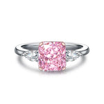 Load image into Gallery viewer, Pink diamond engagement ring with side accent stones on a silver band.
