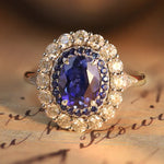 Load image into Gallery viewer, Ornate ring featuring a central oval blue gemstone surrounded by smaller diamonds.
