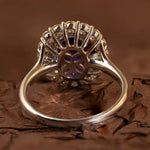 Load image into Gallery viewer, Ornate ring featuring a central oval blue gemstone surrounded by smaller diamonds.
