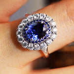 Load image into Gallery viewer, Ornate ring featuring a deep blue gemstone surrounded by smaller diamonds.
