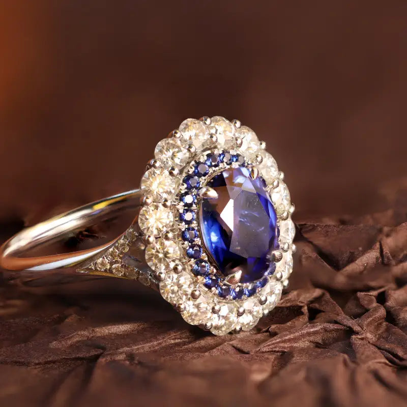 Ornate ring featuring a central blue gemstone surrounded by smaller diamonds.