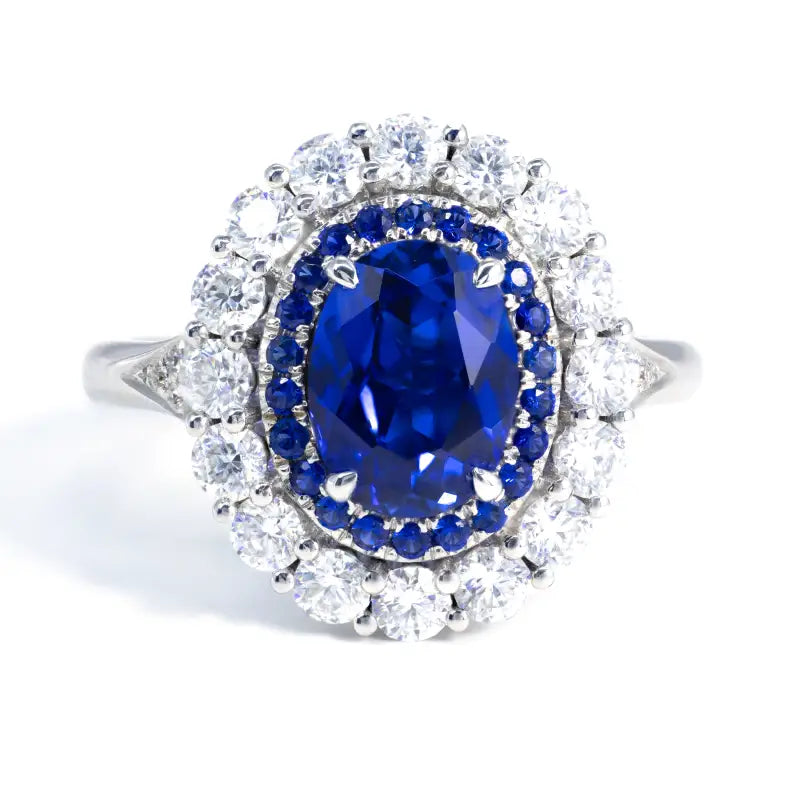 Ornate ring featuring a deep blue oval sapphire surrounded by diamonds.