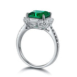 Load image into Gallery viewer, Silver ring featuring a square-cut emerald gemstone surrounded by smaller diamonds.
