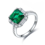 Load image into Gallery viewer, Emerald-cut green gemstone ring with diamond accents set in silver or white gold.
