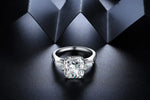 Load image into Gallery viewer, Diamond engagement ring with a prominent center stone and smaller side stones.
