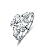 Load image into Gallery viewer, Diamond engagement ring with a prominent oval-cut center stone and two baguette side stones set in a silver-toned band.
