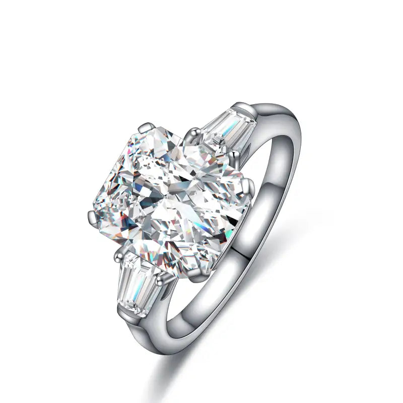 Diamond engagement ring with a prominent oval-cut center stone and two baguette side stones set in a silver-toned band.