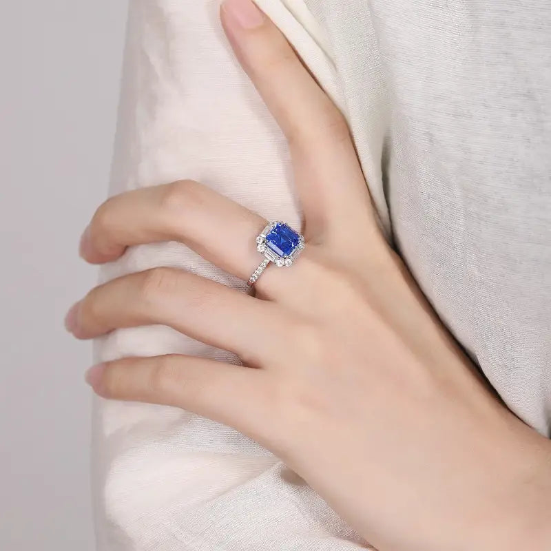 Sapphire and diamond ring on a person’s finger.