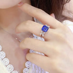 Load image into Gallery viewer, Sapphire and diamond ring on a person’s finger.
