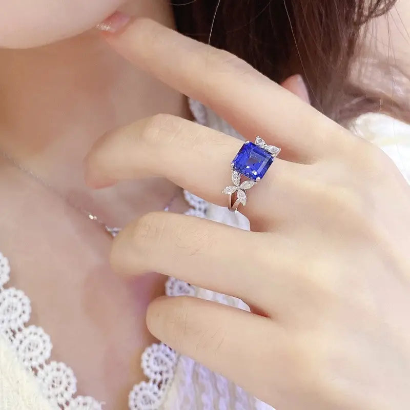 Sapphire and diamond ring on a person’s finger.