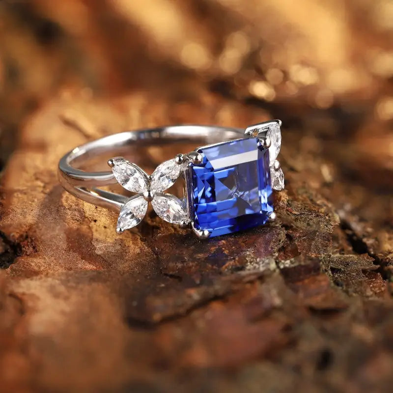 Elegant silver ring featuring a square-cut blue gemstone and diamond accents.