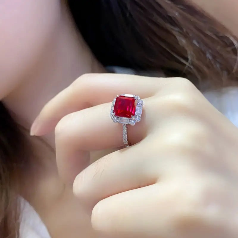 Square-cut ruby ring with diamond halo and band.