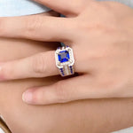 Load image into Gallery viewer, Ornate ring featuring a square-cut blue gemstone surrounded by smaller diamonds.
